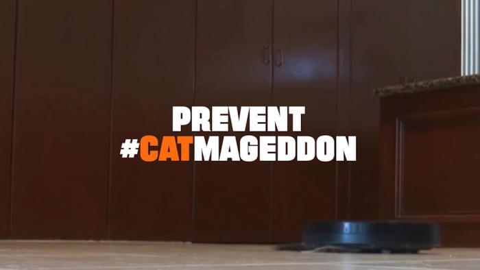 Text “Prevent #CatMageddon” over kitchen floor with robotic vacuum near cabinets.